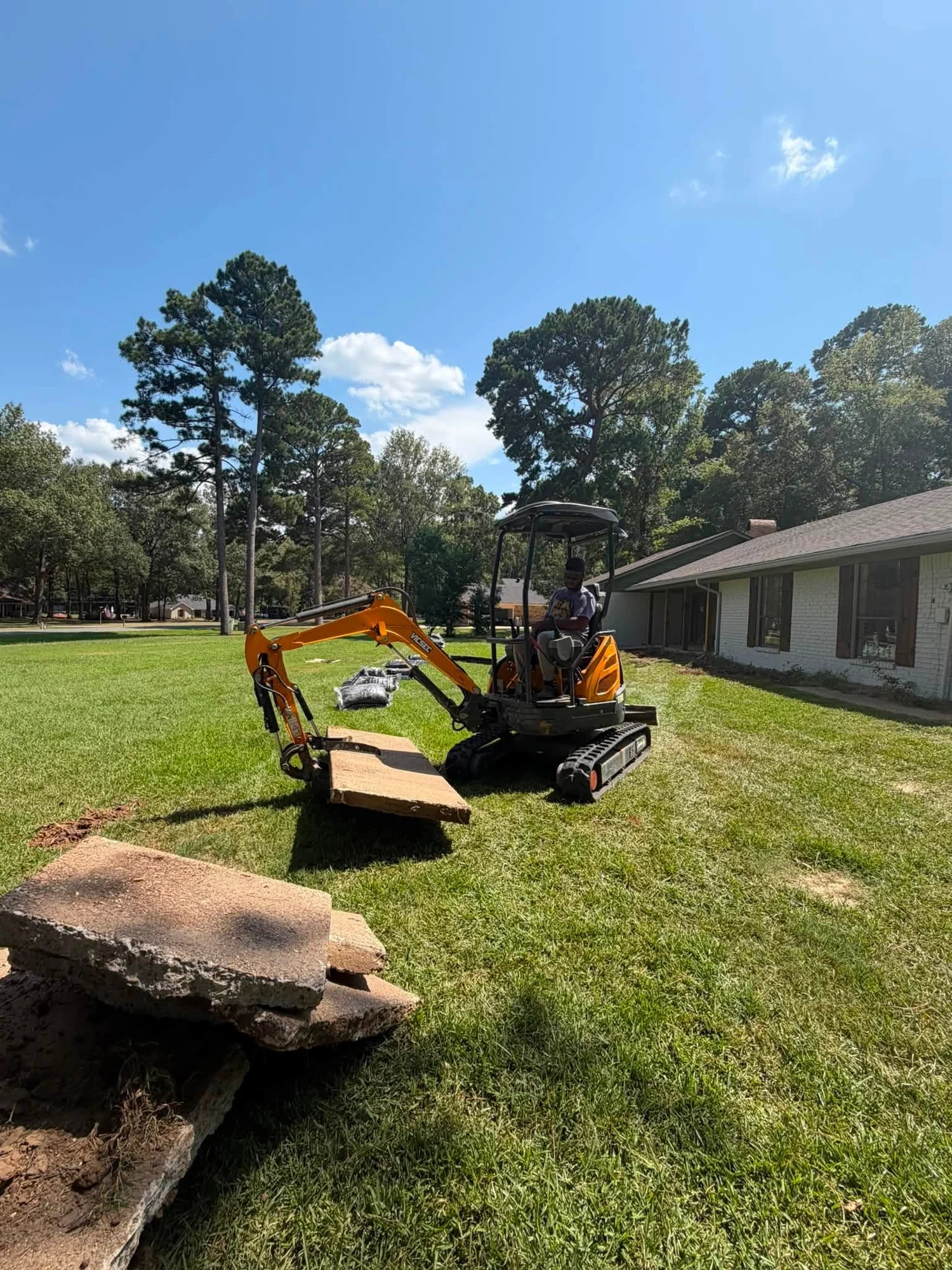 Compact excavator at work on a residential property