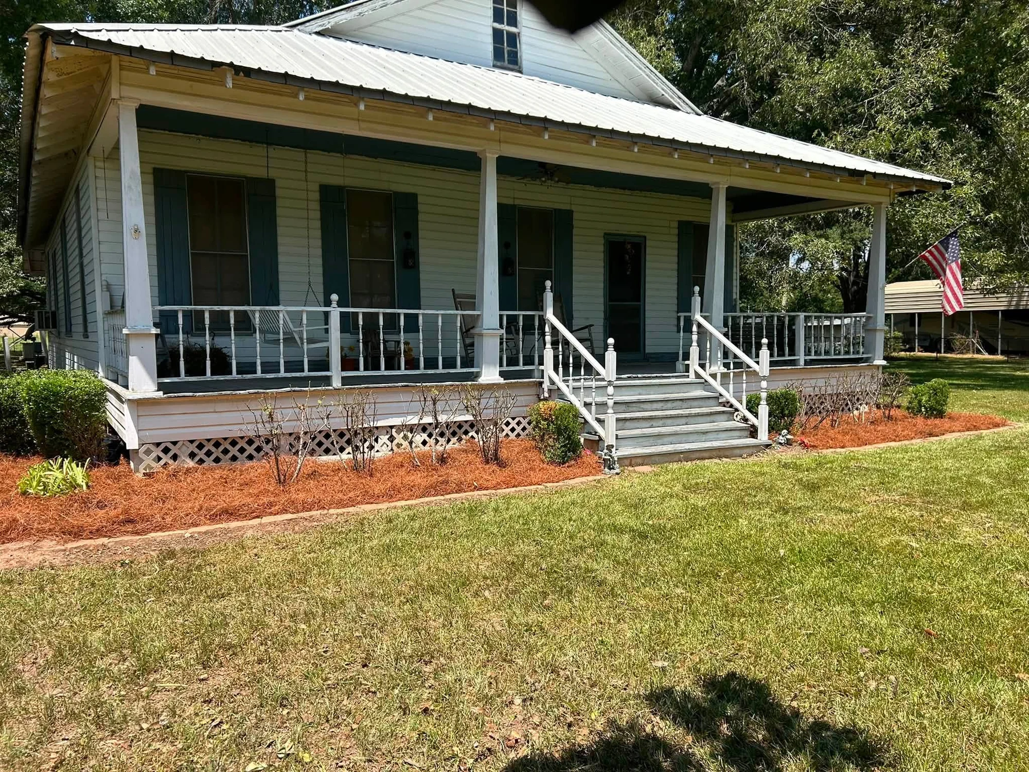 Fresh red mulch installed around a front porch